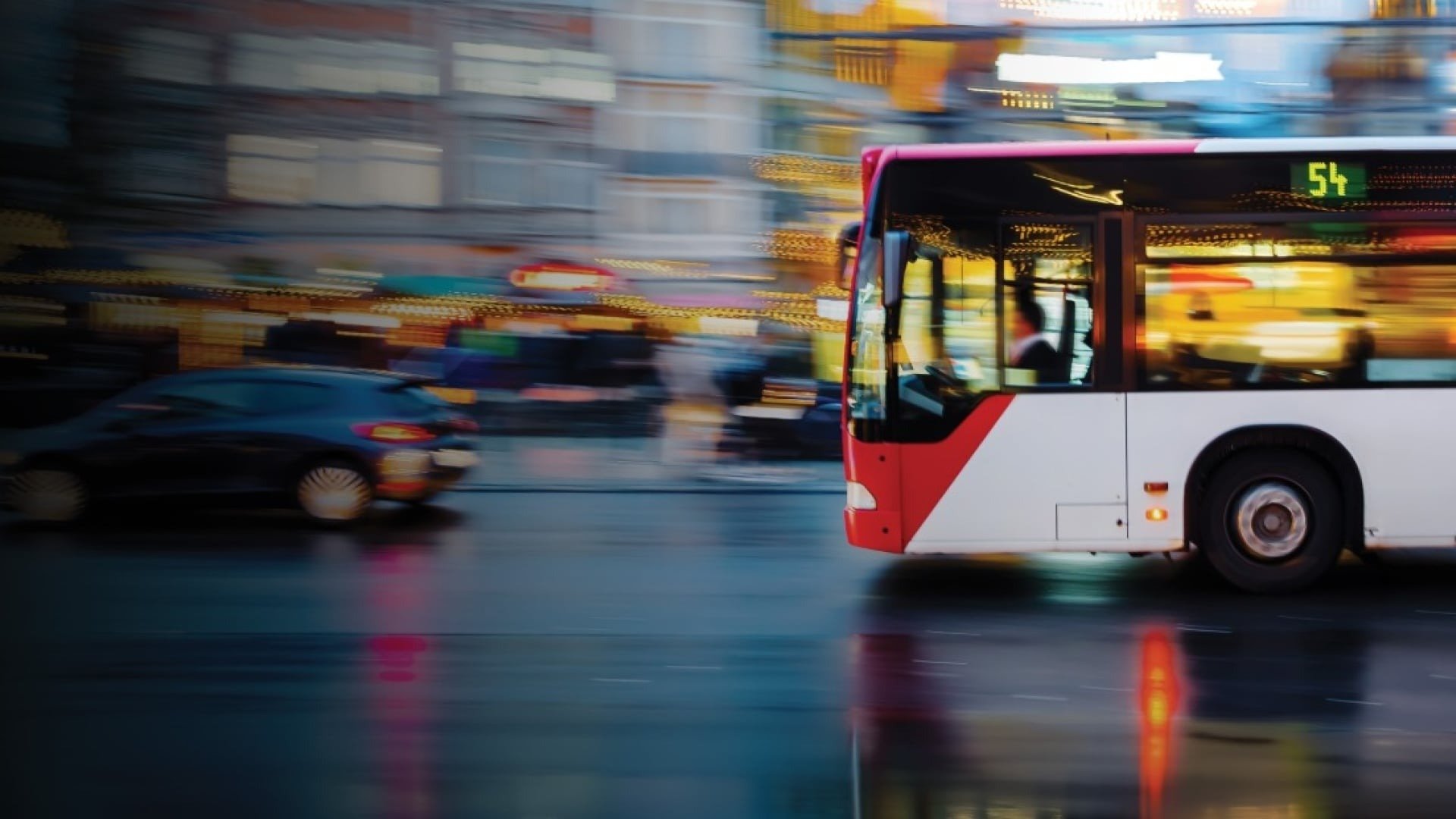 Autobús urbano en movimiento por una avenida de noche